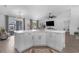 Bright kitchen features white cabinets, quartz countertops, and an island, seamlessly flowing into the living area at 768 Park Valley Cir, Minneola, FL 34715