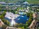 Aerial view of community featuring a lake, pool, clubhouse, and lush green landscaping at 8312 Fontera Dr, Davenport, FL 33896