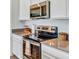 Close-up of the kitchen showcasing stainless steel appliances and gray countertops at 945 Laurel View Way, Groveland, FL 34736