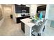 Modern kitchen featuring sleek, dark cabinetry, stainless steel appliances and a bright breakfast bar at 945 Laurel View Way, Groveland, FL 34736