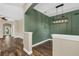 Elegant dining room featuring wood-look floors, modern light fixture, and stylish green accent wall at 1318 Horizon Creek Ct, Orlando, FL 32828