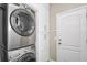 Laundry room features stacked washer/dryer and storage cabinets with a door for access at 1318 Horizon Creek Ct, Orlando, FL 32828