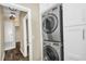 Modern laundry room with a stacked washer and dryer next to a hallway at 1318 Horizon Creek Ct, Orlando, FL 32828