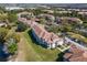 Aerial view of condo community featuring terracotta roofs, ample parking, and beautiful green landscaping and waterscapes at 13929 Fairway Island Dr # 825, Orlando, FL 32837