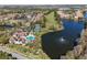 Aerial of community pool, tennis courts, lake, and water fountain in a scenic neighborhood at 13929 Fairway Island Dr # 825, Orlando, FL 32837