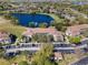 Aerial view of lakeside condos featuring terracotta roofs and ample parking, showcasing serene water and green surroundings at 13929 Fairway Island Dr # 825, Orlando, FL 32837