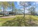 Outdoor community space with picnic tables, BBQ and green grass, surrounded by condos and trees at 13929 Fairway Island Dr # 825, Orlando, FL 32837