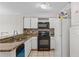 Kitchen featuring granite countertops, white cabinets, and a black appliance set at 13929 Fairway Island Dr # 825, Orlando, FL 32837