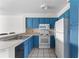 Bright kitchen featuring blue cabinets, a white refrigerator, and functional appliances at 14013 Fairway Island Dr # 434, Orlando, FL 32837