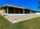 Exterior view of the home, showcasing the screened-in patio and brick-paved area extending into the lawn at 1556 Lemon Ave, Winter Haven, FL 33881