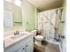 Cozy bathroom featuring white vanity, toilet, and shower with white and gold marble curtain at 1556 Lemon Ave, Winter Haven, FL 33881