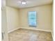 Clean, empty bedroom featuring a window with blinds and neutral-toned walls at 1556 Lemon Ave, Winter Haven, FL 33881