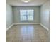 Light-filled bedroom features a window with blinds, neutral walls, and tiled floors at 1556 Lemon Ave, Winter Haven, FL 33881