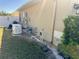 Tan home with a generator, exterior plumbing fixtures, and a white fence at 1556 Lemon Ave, Winter Haven, FL 33881