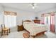 Bright bedroom with decorative curtains, ceiling fan, and tiled floor at 165 Coralwood Cir, Kissimmee, FL 34743