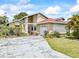 Inviting single-story home featuring a charming front yard, driveway, and attached garage at 165 Coralwood Cir, Kissimmee, FL 34743