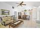 Comfortable living room featuring tile flooring, a ceiling fan, and view of dining room at 165 Coralwood Cir, Kissimmee, FL 34743