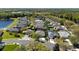 Community aerial view of homes with mature trees and a scenic lake at 1659 Cherry Blossom Ter, Lake Mary, FL 32746