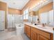 Bathroom featuring a double sink vanity, a bathtub, and a glass-enclosed shower at 1659 Cherry Blossom Ter, Lake Mary, FL 32746