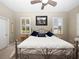 Comfortable bedroom featuring a metal frame bed, neutral walls, and plantation shutters on the windows at 1659 Cherry Blossom Ter, Lake Mary, FL 32746