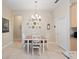 Inviting dining room features wooden table, white chairs, a decorative plate wall, and modern chandelier at 1659 Cherry Blossom Ter, Lake Mary, FL 32746