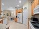 Bright kitchen featuring wooden cabinets, white appliances, and tiled floors at 1659 Cherry Blossom Ter, Lake Mary, FL 32746