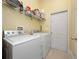 Practical laundry room featuring a washer, dryer, and ample storage shelving for convenience at 1659 Cherry Blossom Ter, Lake Mary, FL 32746