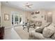 Comfortable living room featuring plush sofas, ceiling fan, and sliding glass doors to outdoor pool at 1659 Cherry Blossom Ter, Lake Mary, FL 32746