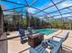 Screened-in pool area with seating around a gas fire pit, perfect for outdoor relaxation and entertainment at 1659 Cherry Blossom Ter, Lake Mary, FL 32746