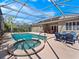 Inviting screened pool area with spa, lounge seating, and lush tropical landscaping at 1659 Cherry Blossom Ter, Lake Mary, FL 32746