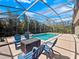 Inviting screened pool area with comfortable lounge seating and lush tropical landscaping at 1659 Cherry Blossom Ter, Lake Mary, FL 32746