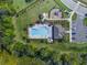 Aerial view of community pool, playground, parking, cabana, with mature landscaping and trees nearby at 17394 Million Lakes Ct, Clermont, FL 34714