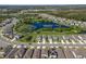 An aerial view showcases homes in a well-planned community with a scenic lake and green spaces at 17394 Million Lakes Ct, Clermont, FL 34714