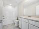 Modern bathroom with a bathtub-shower combo, white vanity, and bright lighting at 17394 Million Lakes Ct, Clermont, FL 34714