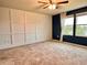 Spacious bedroom with carpeted floors, decorative wall accents, and large windows offering scenic views at 17394 Million Lakes Ct, Clermont, FL 34714