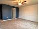 Large bedroom featuring contemporary wall paneling, neutral carpet, and a fresh coat of deep blue paint at 17394 Million Lakes Ct, Clermont, FL 34714