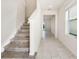 Bright entryway featuring tile flooring, a staircase, and an open view into the rest of the home at 17394 Million Lakes Ct, Clermont, FL 34714