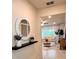 Bright entryway showcasing a round mirror, floating shelf with plants, and a glimpse into the living room at 17394 Million Lakes Ct, Clermont, FL 34714