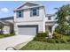 Charming two-story home featuring light gray siding, blue shutters, a two-car garage, and well-maintained landscaping at 17394 Million Lakes Ct, Clermont, FL 34714