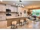 Modern kitchen with stainless steel appliances, a spacious island with bar seating, and open dining area at 17394 Million Lakes Ct, Clermont, FL 34714