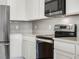 Close up of the kitchen stove and stainless steel appliances and grey back splash at 17394 Million Lakes Ct, Clermont, FL 34714