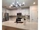 Modern kitchen with stainless steel appliances and a spacious island with a black sink faucet at 17394 Million Lakes Ct, Clermont, FL 34714
