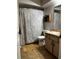 Bathroom featuring tile flooring, classic shower and curtain, wood cabinet and sink at 17411 Hillside Dr, Montverde, FL 34756