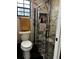 Modern bathroom with a glass-enclosed shower featuring decorative tiles and a window at 17411 Hillside Dr, Montverde, FL 34756