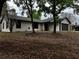 Charming ranch-style house with neutral color and dark trim on a spacious, tree-filled lot at 17411 Hillside Dr, Montverde, FL 34756