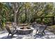 Relaxing outdoor fire pit with seating area, nestled among trees, perfect for gathering and enjoying the natural surroundings at 1814 Old Stable Pt, Chuluota, FL 32766