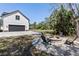 Outdoor stone fire pit with seating next to the garage and a view of the backyard and gazebo at 1814 Old Stable Pt, Chuluota, FL 32766