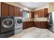 Spacious laundry room featuring modern washer, dryer, sink, and cabinetry at 1814 Old Stable Pt, Chuluota, FL 32766