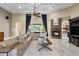 Elegant living room featuring a cozy fireplace, large windows, and a comfortable leather sectional at 1814 Old Stable Pt, Chuluota, FL 32766