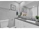 Bathroom with double sink vanity, dark countertop, two mirrors, and tiled walls at 2012 Dorris Dr, Orlando, FL 32807